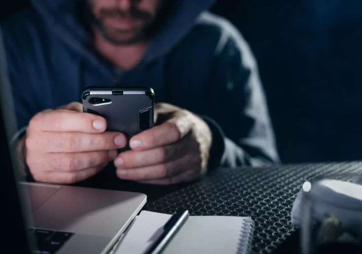 Symbolfoto von 5min.at: Krimineller hackt ein Passwort auf einem Telefon.