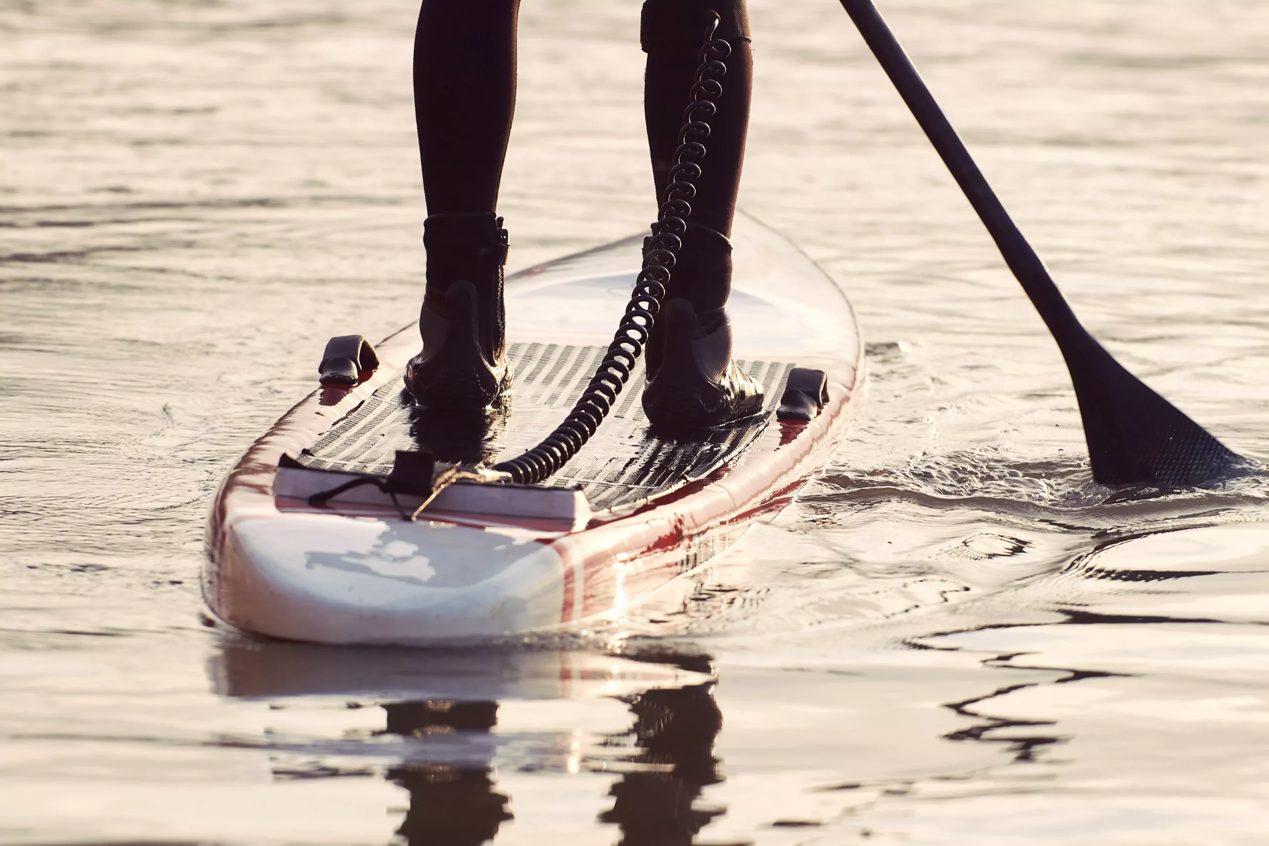 Symbolfoto von 5min.at: Person paddelt mit einem Stand Up Paddel am See.