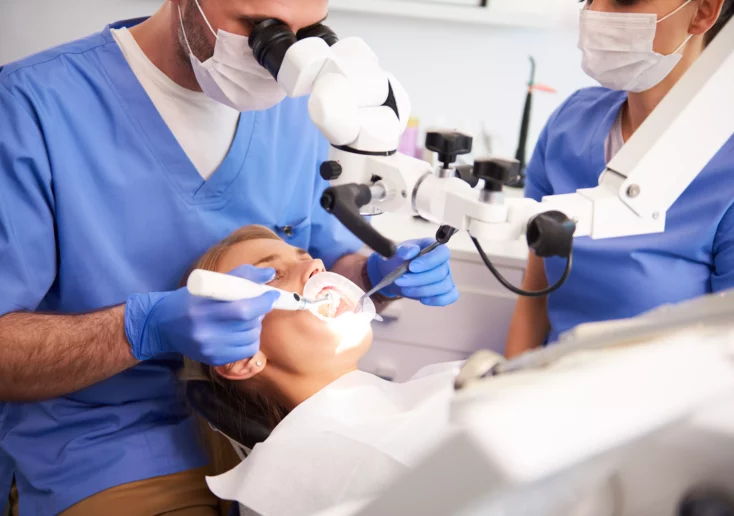 Symbolfoto von 5min.at: Zahnarzt kontrolliert die Zähne einer Patientin.