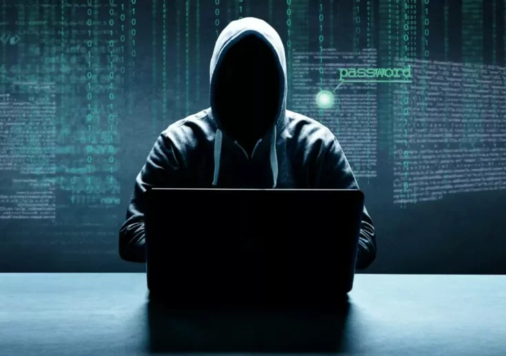 Symbolfoto zu einem Beitrag von 5min.at: Ein Hacker arbeitet an einem Laptop, im Hintergrund schwebt Code in der Luft
