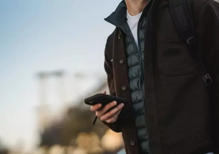 Symbolfoto zu einem Beitrag von 5min.at: Ein Mann hält ein Handy in der Hand