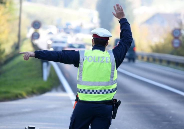 Symbolfoto zu einem Beitrag von 5min.at: Ein Polizist kontrolliert Verkehrsteilnehmer.