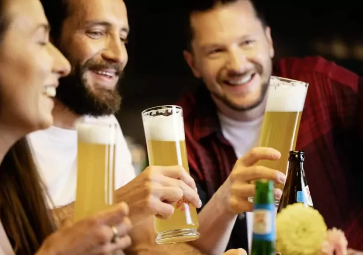 Symbolfoto von 5min.at: Freunde sitzen zusammen und trinken gemütlich ein Bier.