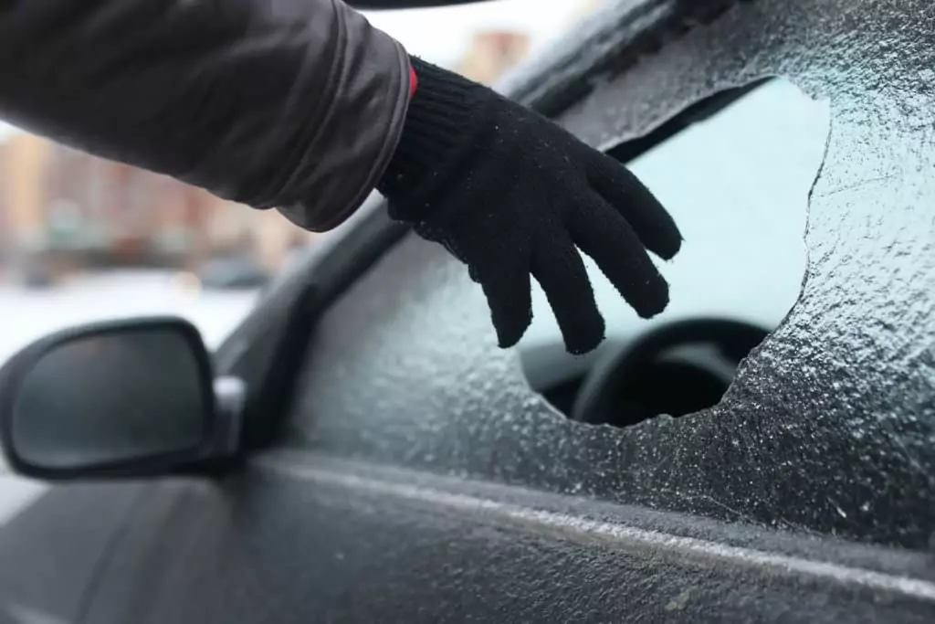 Symbolfoto von 5min.at: Dieb bricht über das Fenster in ein Auto ein.
