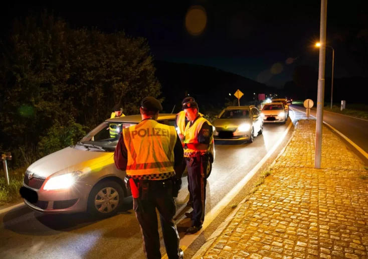 Symbolfoto zu einem Beitrag von 5min.at: Polizisten kontrollieren Autos bei Nacht