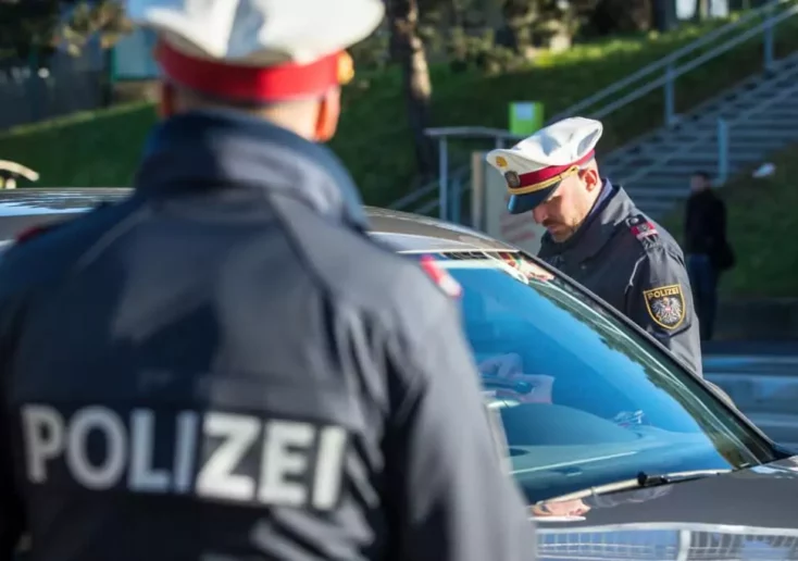 Symbolfoto von 5min.at: Polizisten kontrollieren den Führerschein eines Autofahrers.