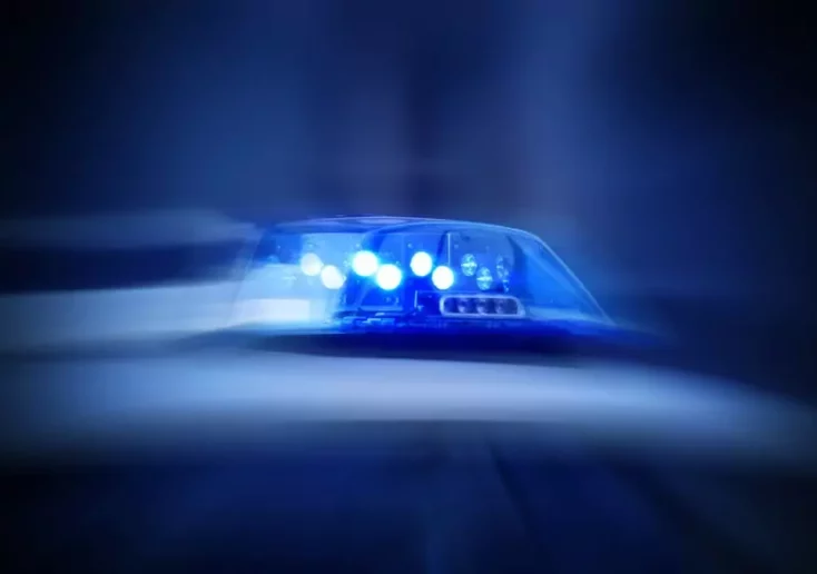 Symbolfoto von 5min.at: Polizeiauto mit eingeschaltetem Blaulicht bei Nacht.