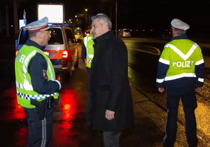 Symbolfoto von 5min.at: Polizei im Nachteinsatz. Beamter spricht mit Bundeskanzler Karl Nehammer.