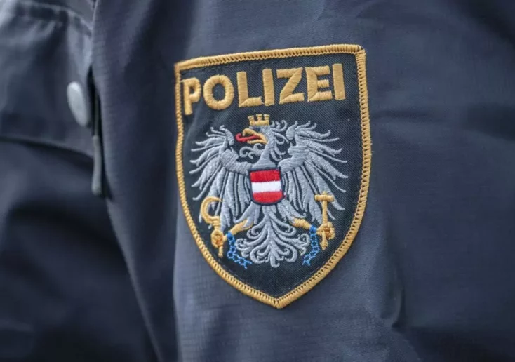 Symbolfoto von 5min.at: Nahaufnahme von einem Polizeiwappen an einer Uniform.