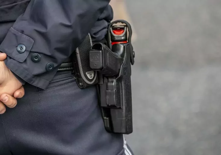Symbolfoto von 5min.at: Nahaufnahme eines bewaffneten Polizisten mit Pfefferspray.
