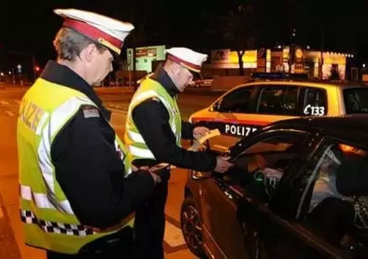 Symbolfoto von 5min.at: Polizisten bei einer Verkehrskontrolle in der Nacht.
