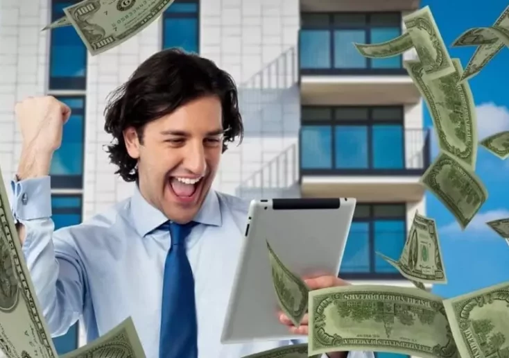 Symbolfoto von 5min.at: Mann sieht auf ein Tablet und freut sich über einen Geldgewinn.