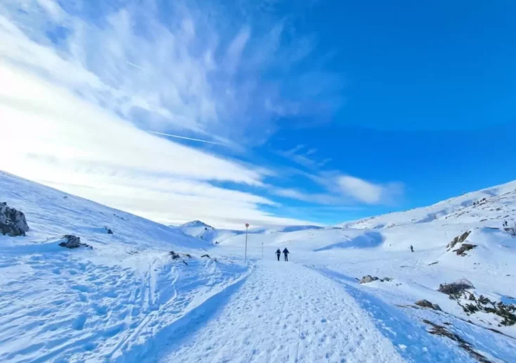 Symbolfoto zu einem Beitrag von 5min.at: schneebedeckter Berg mit Wanderer