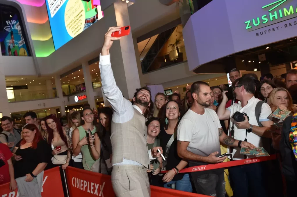 Ein Foto auf 5min.at zeigt Paul Pizzera beim Selfies machen mit Fans bei der Pulled Pork Premiere.