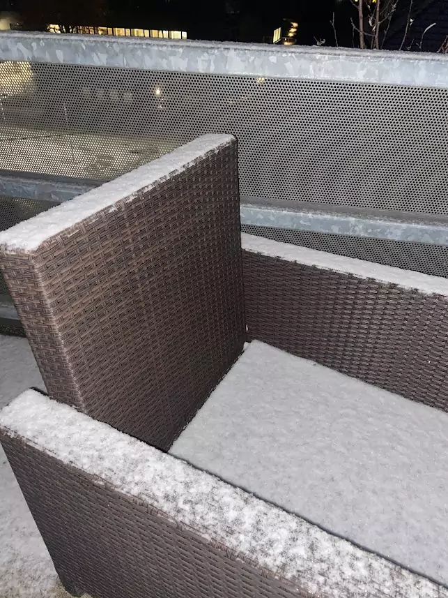 Foto in Beitrag von 5min.at: Zu sehen ist ein wenig Schnee auf einem Balkonstuhl in Klagenfurt.