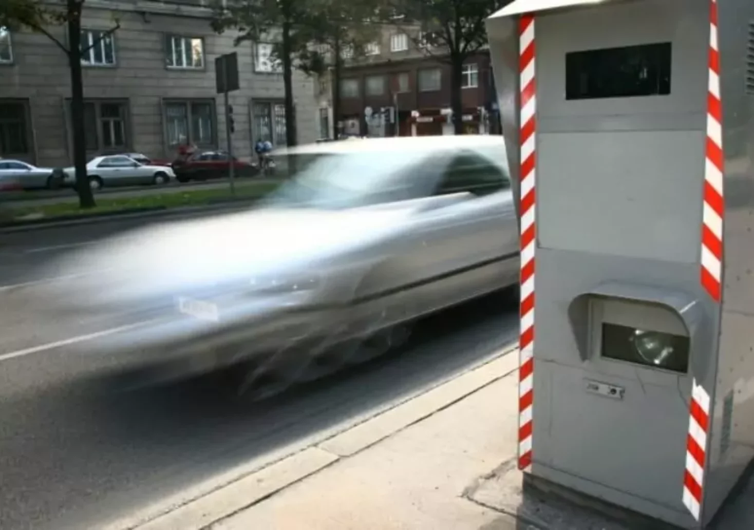 Foto in Beitrag von 5min.at: Zu sehen ist ein Radarkasten, an dem ein Auto vorbeifährt.
