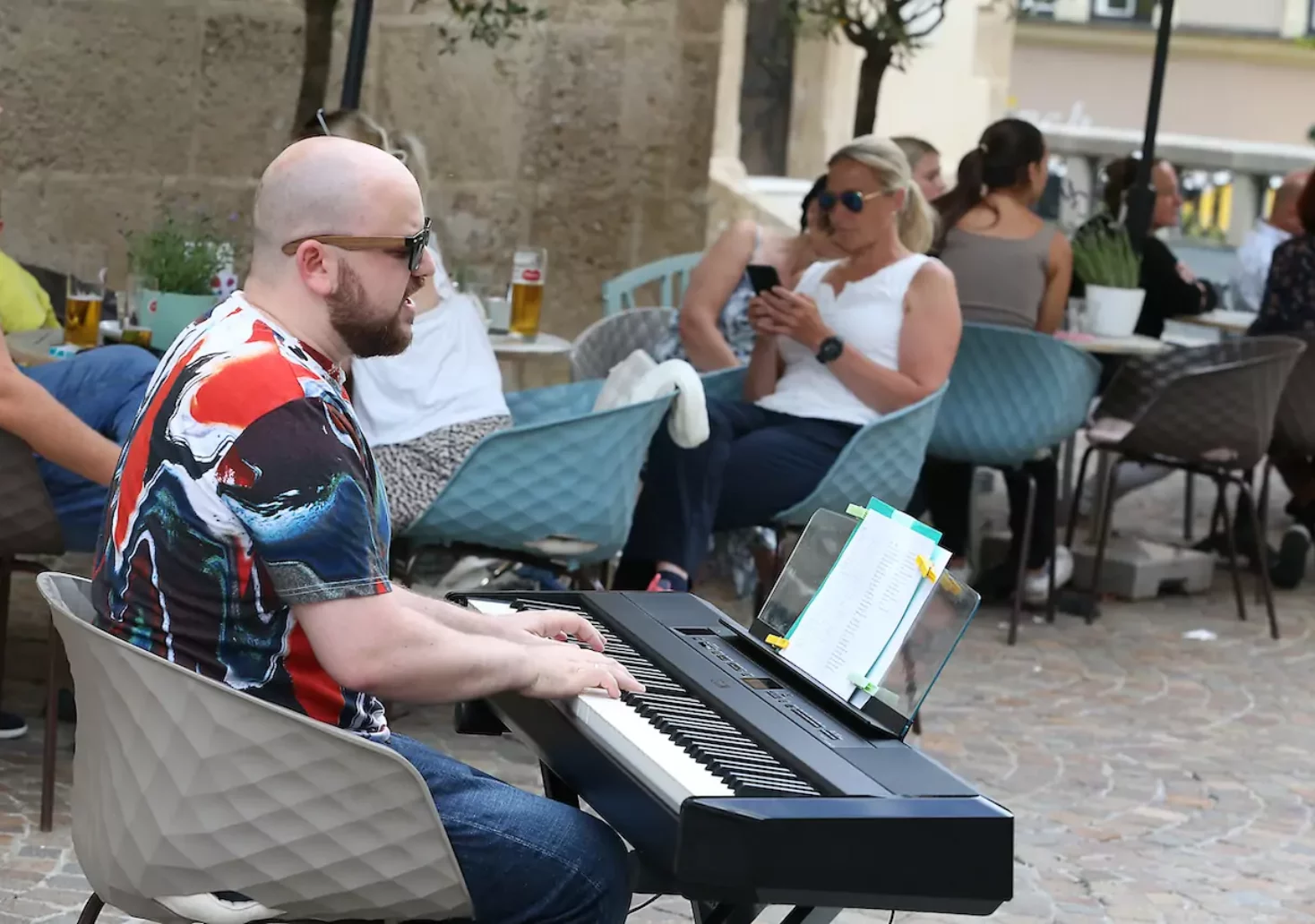 Foto auf 5min.at zeigt einen Mann, der im Freien auf einem Keyboard spielt.