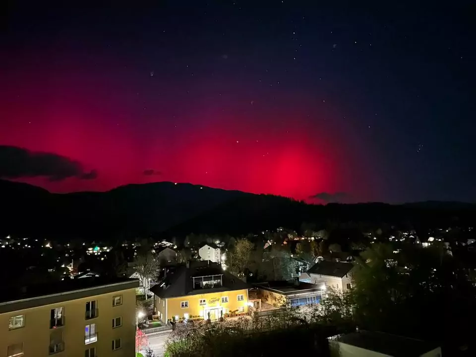 The image on 5min.at shows the pink northern lights twinkling in the Villach night sky.
