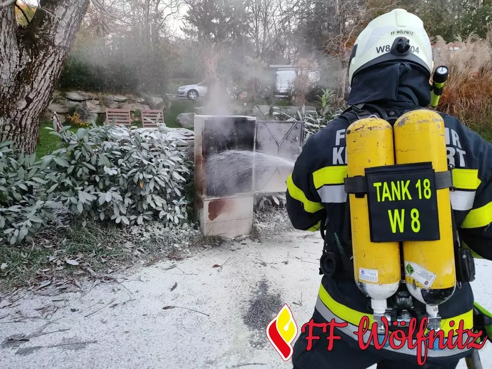 Ein Bild auf 5min.at zeigt einen Feuerwehrmann, der einen brennenden Stromverteiler löscht.