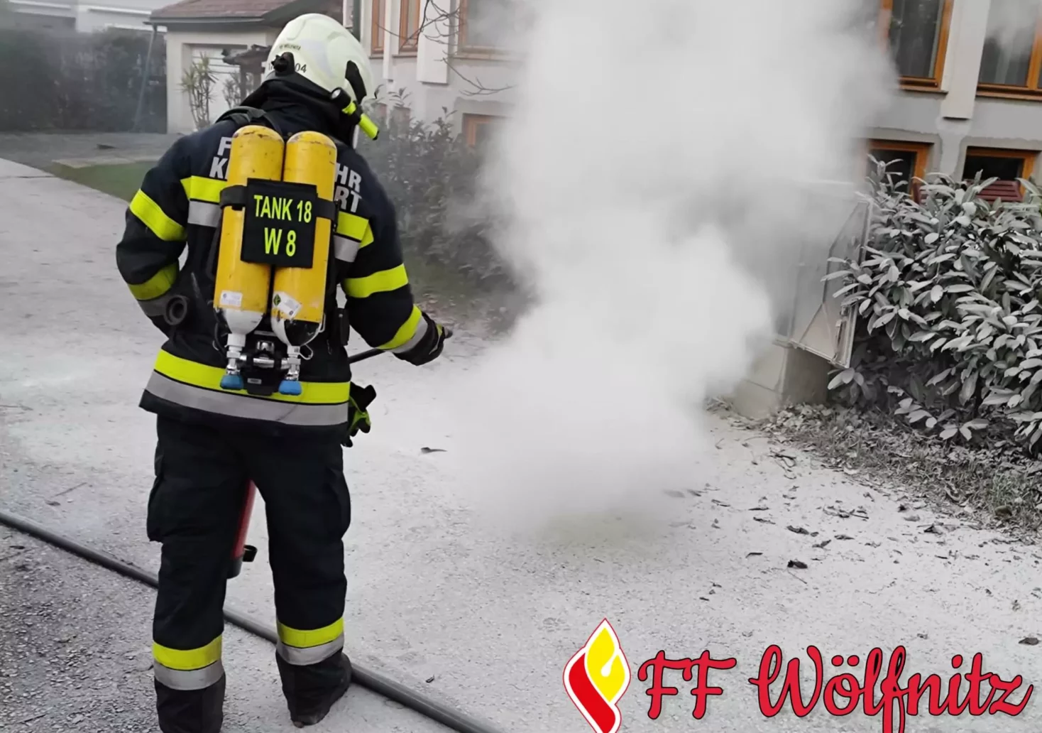 Ein Bild auf 5min.at zeigt einen Feuerwehrmann, der einen brennenden Stromverteiler löscht.