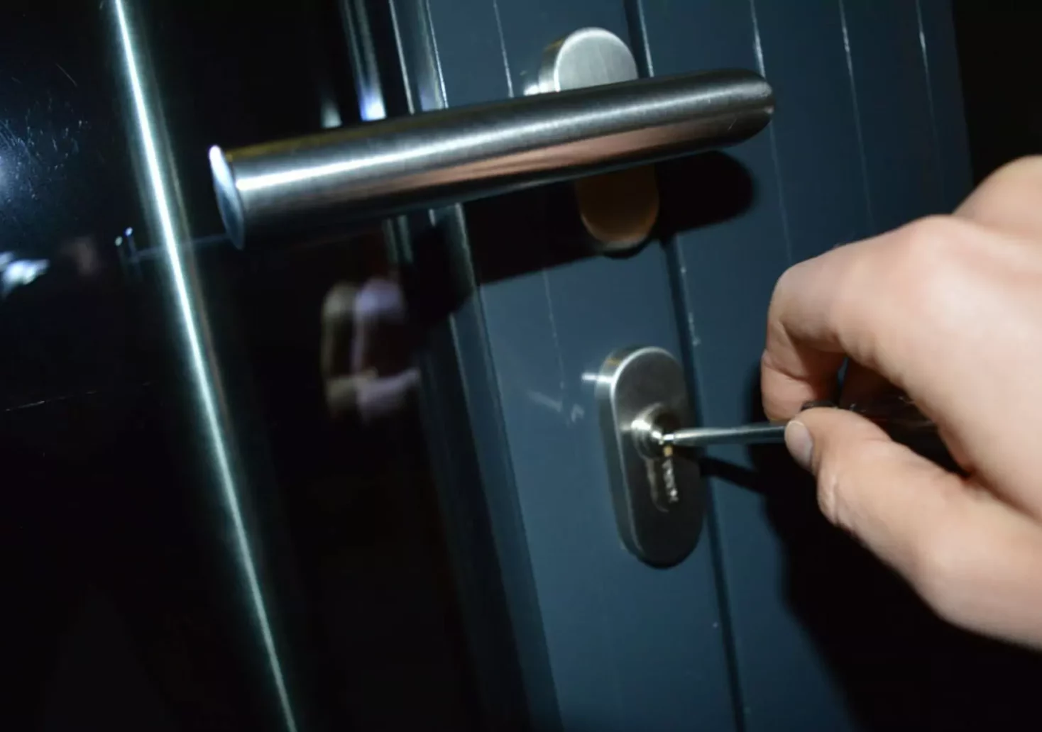 Ein Bild auf 5min.at zeigt, wie jemand bei Nacht versucht, eine Tür mit einem Werkzeug aufzubrechen.