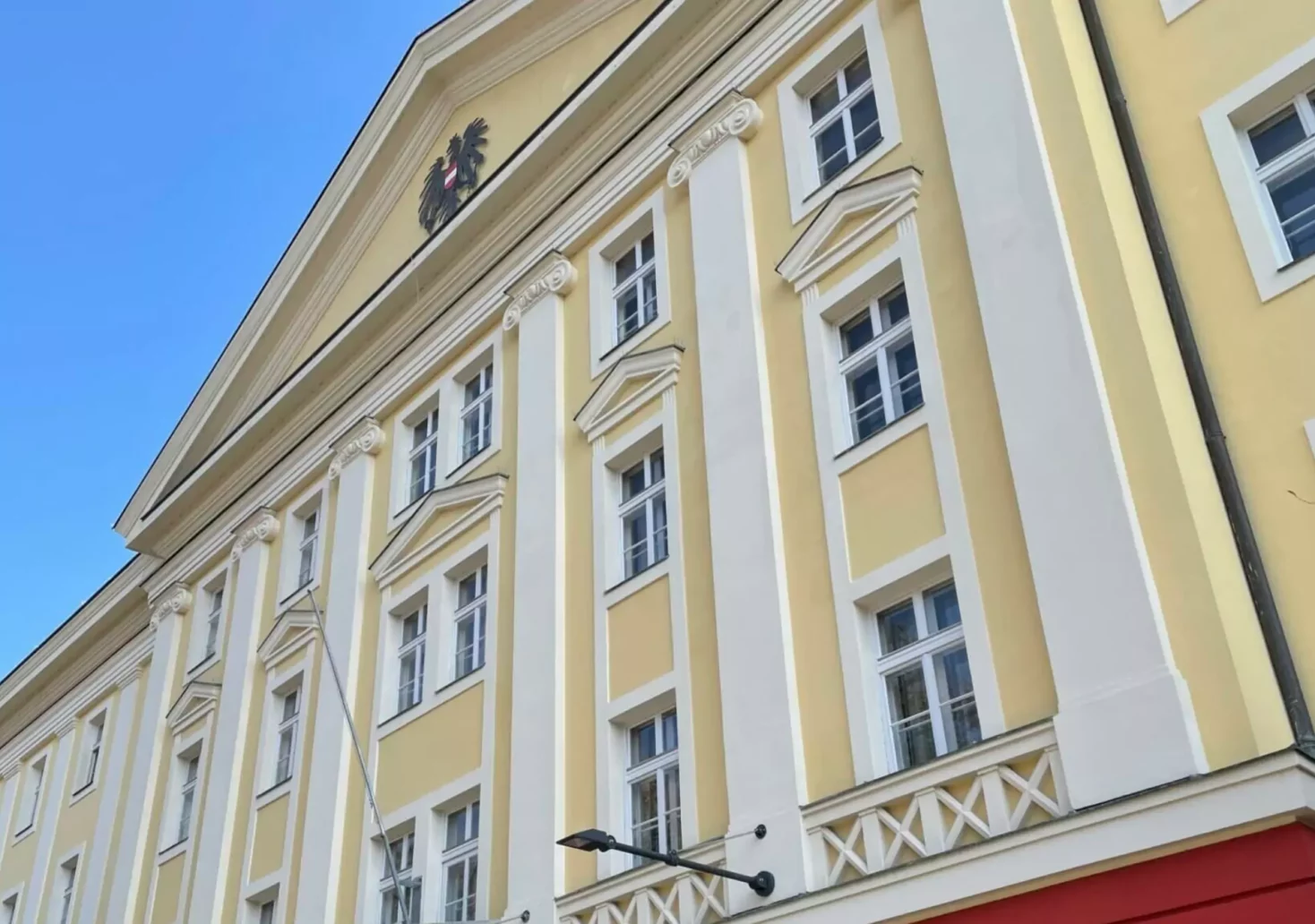 Ein Bild auf 5min.at zeigt die gelb, rote Außenfassade des Kärntner Landesgerichts.