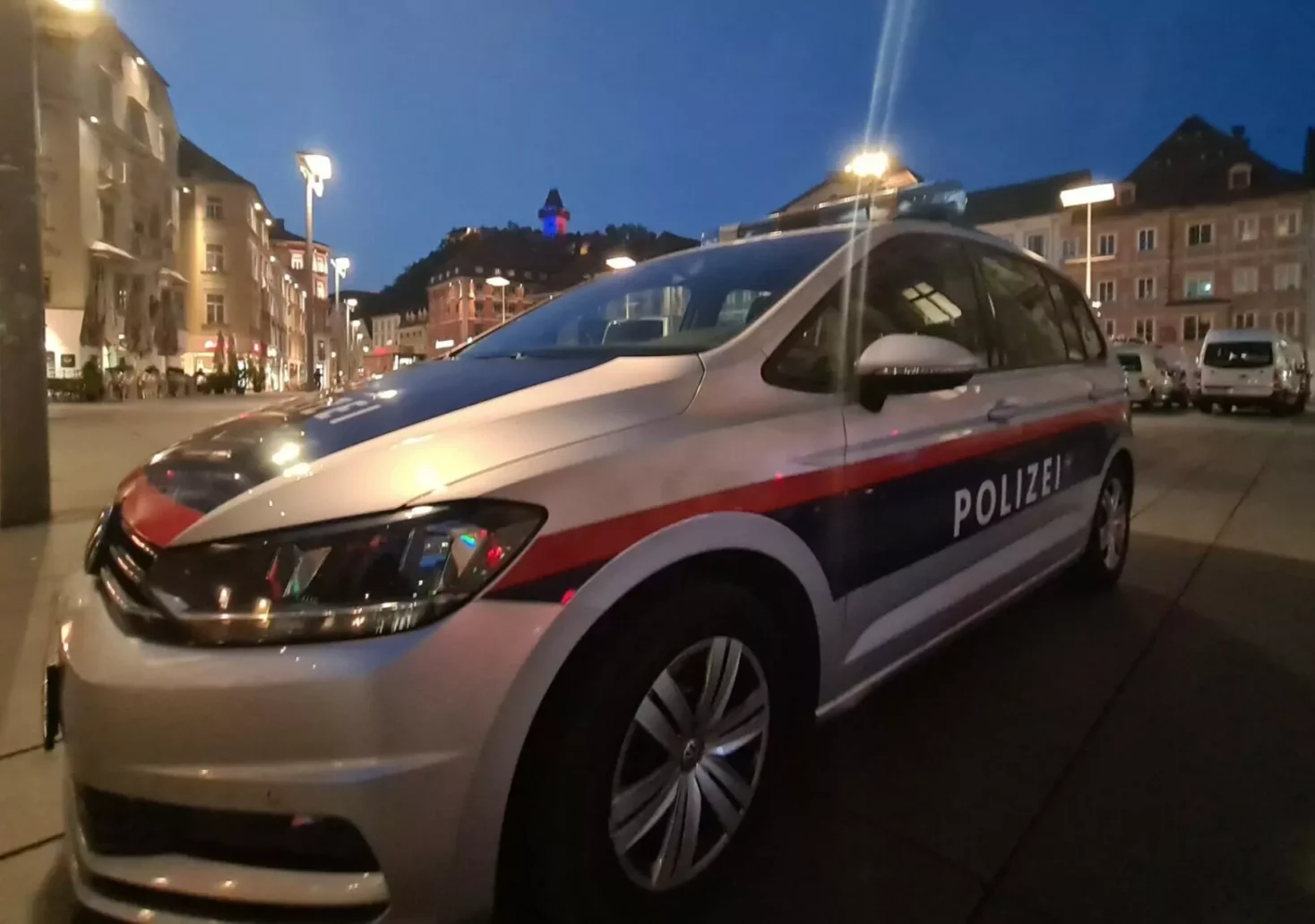 Ein Bild auf 5min.at zeigt ein Polizeiauto in Graz bei Nacht.
