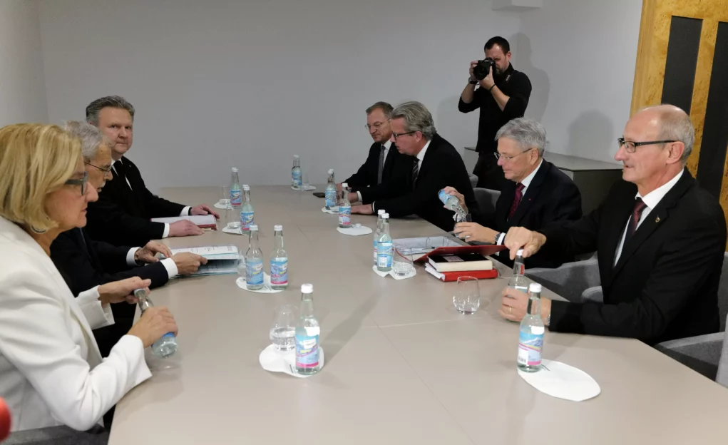 Ein Foto auf 5min.at zeigt Bundespräsident Alexander Van der Bellen im Austausch mit den Landeshauptleuten. Sie alle sitzen an einem Sitzungstisch. Ein Pressefotograf steht im Hintergrund.