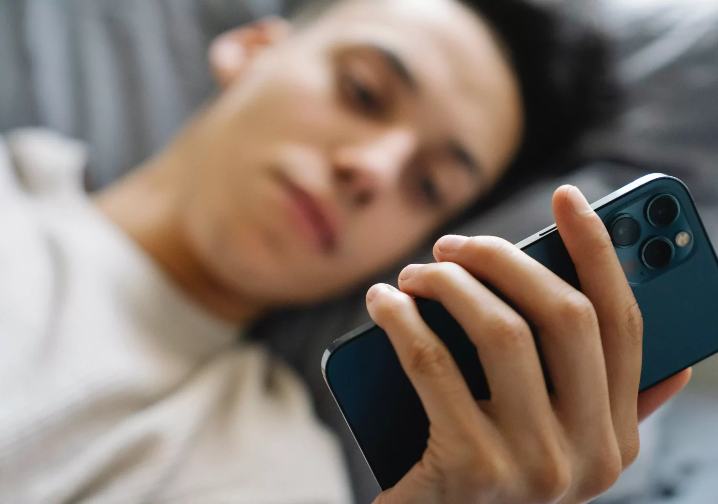 Ein Bild auf 5min.at zeigt einen jungen Mann mit einem Handy in der Hand.