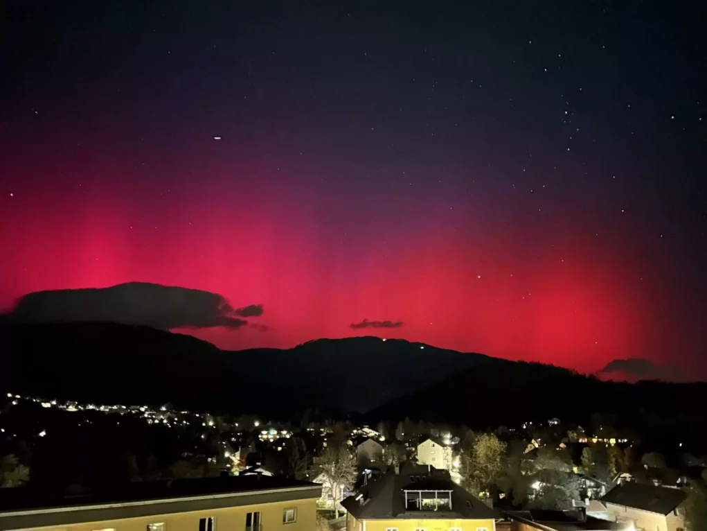 The image on 5min.at shows the pink northern lights twinkling in the night sky.