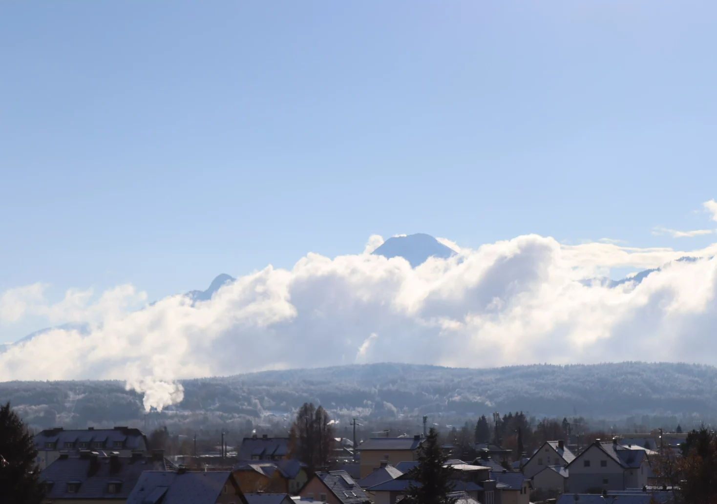 Ein Bild auf 5min.at zeigt das verschneite Villach vor einer Bergkulisse. Der Himmel ist blau.