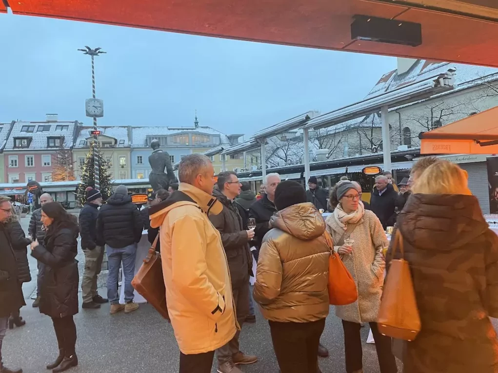 Foto in Beitrag von 5min.at: Zu sehen sind mehrere Menschen bei der Neueröffnung des neuen Frierss am Benediktinermarkt.