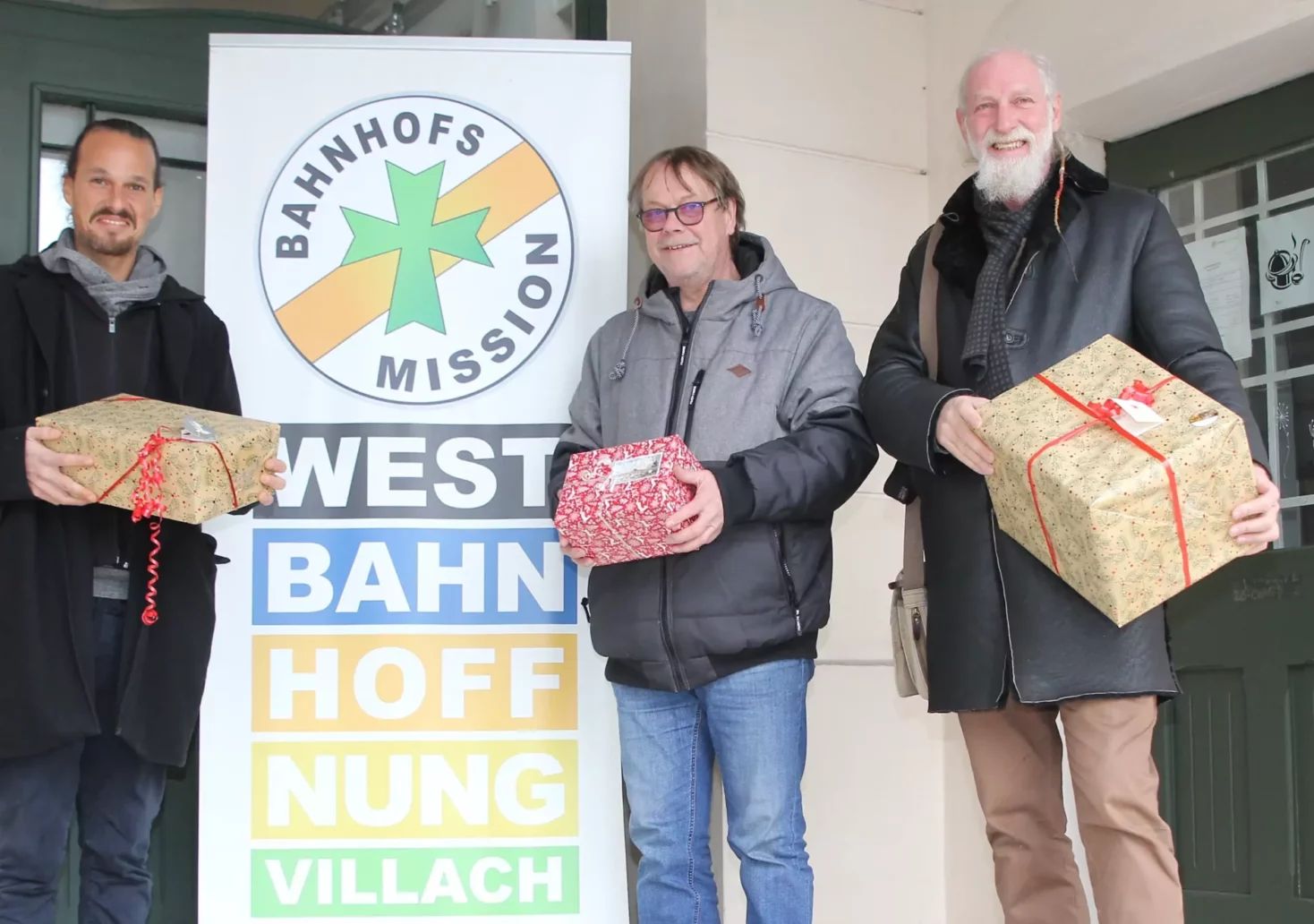 Das Bild auf 5min.at zeigt: Stadtrat Sascha Jabali Adeh und Gemeinderat Herbert Tarmann die Weihnachtsgeschenke an Westbahnhoffnung-Obmann Marjan Kac übergeben.