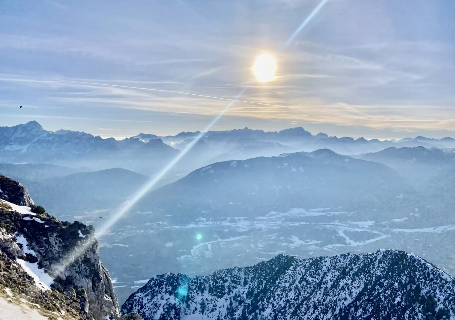 Ein Bild auf 5min.at zeigt die Aussicht vom Dobratsch. Die Sonne scheint über einer vernebelten Bergkulissen.