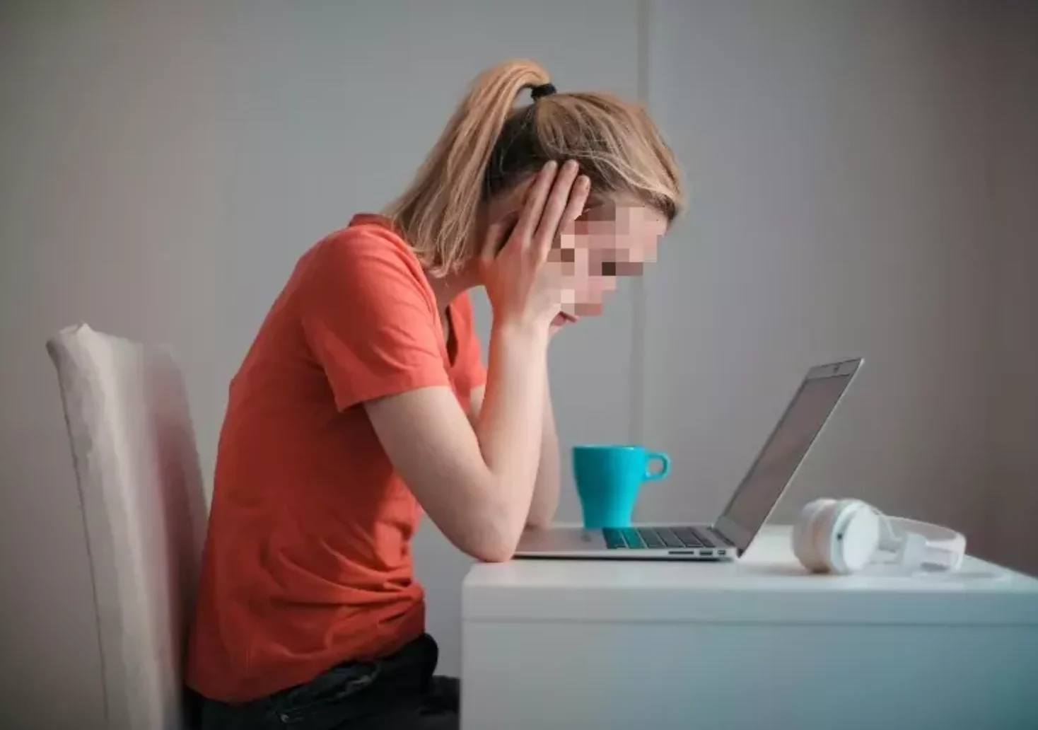 Symbolfoto auf 5min.at zeigt eine junge Frau vor einem Laptop sitzen.