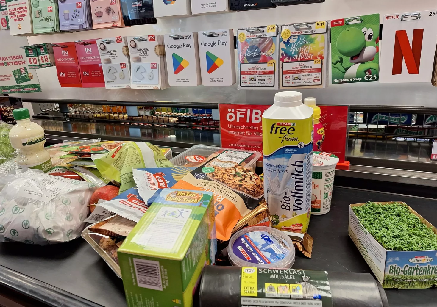 Ein Bild auf 5min.at zeigt Lebensmittel auf dem Kassenband eines Supermarktes.