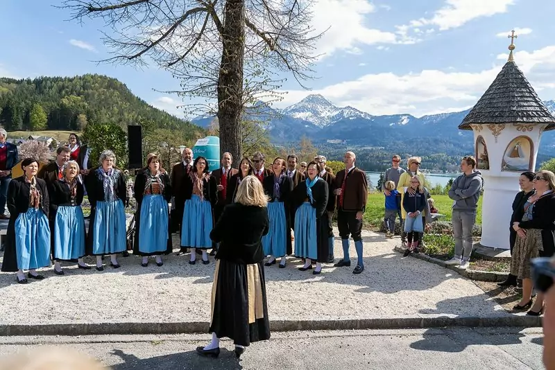 Ein Bild auf 5min.at zeigt einen Chor beim offenen Singen beim Materl am Faaker See.