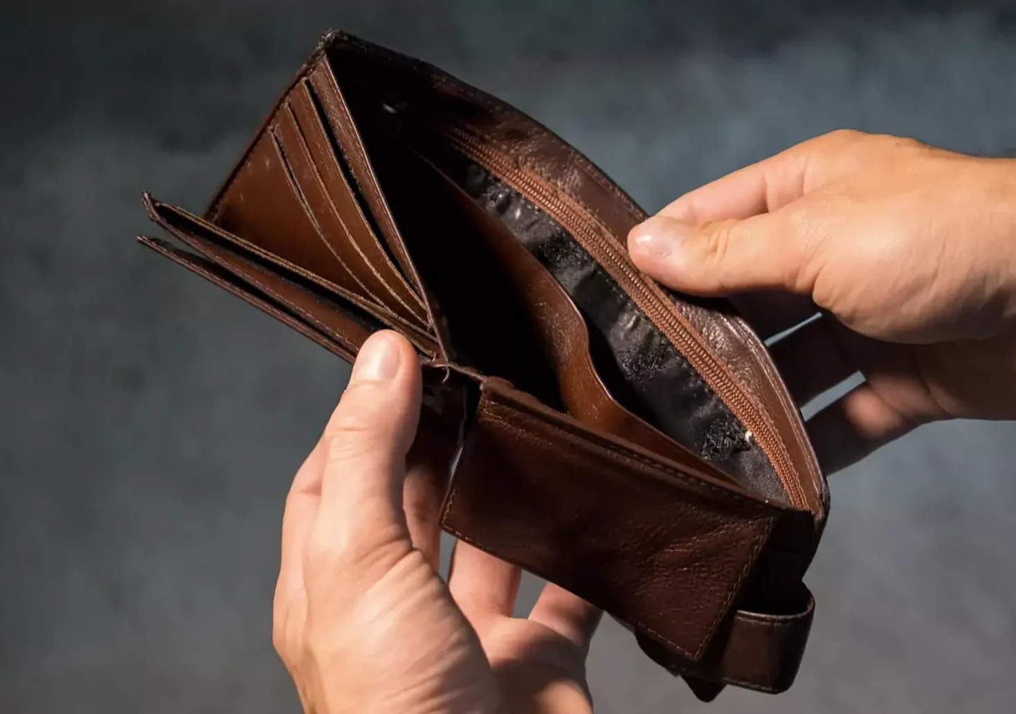 Foto in Beitrag von 5min.at: Zu sehen ist eine Person bzw. die Hände dieser Person, die eine leere Geldtasche aufhält.