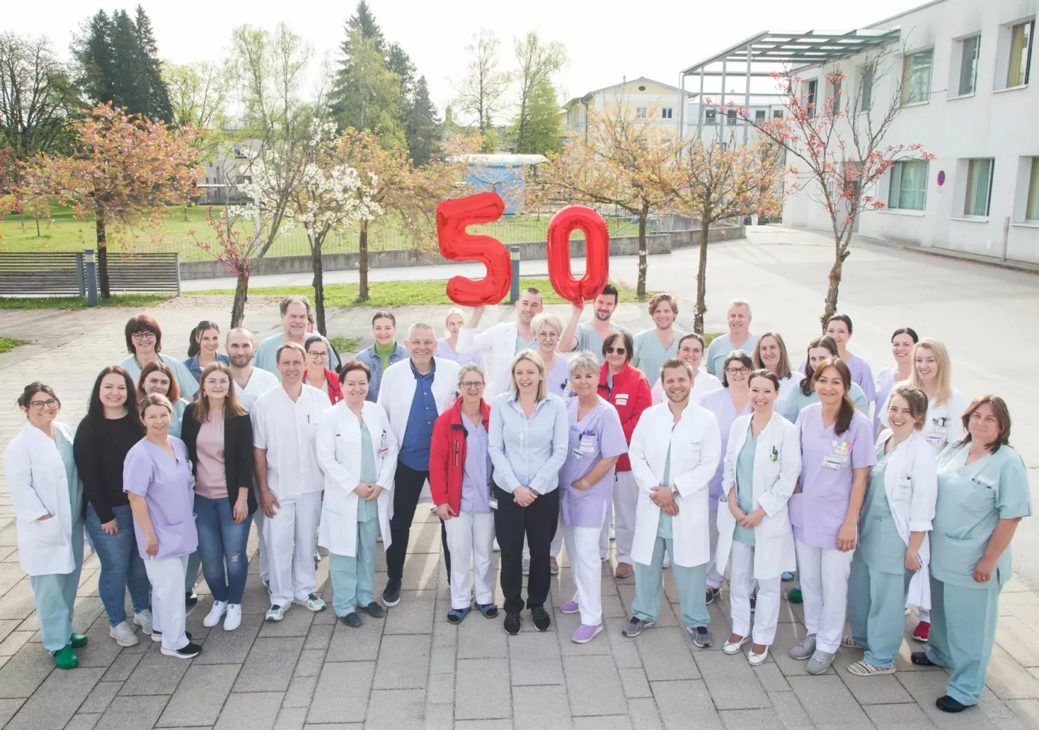 Das Foto auf 5min.at zeigt eine Gruppe von Krankenhausangestellten mit zwei Luftballons.
