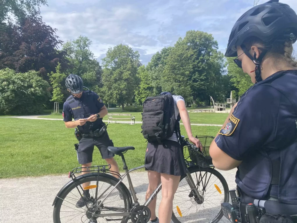 Bild auf 5min.at zeigt zwei Polizisten bei einer Fahrrad-Kontrolle. Eine frau auf einem Fahrrad wird kontrolliert.