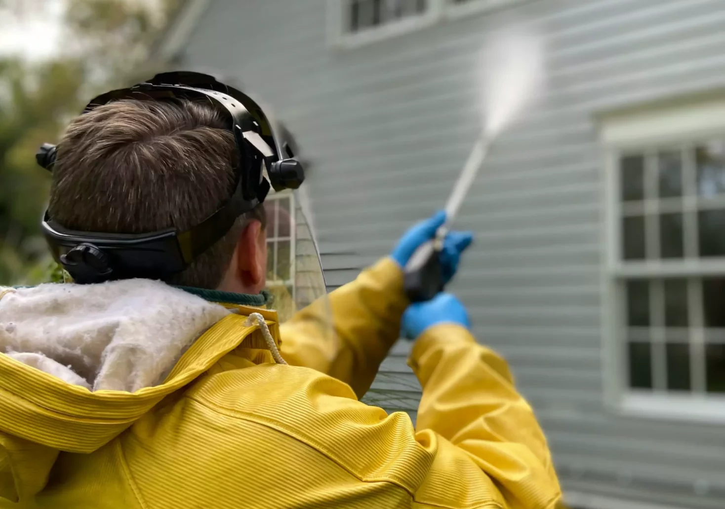 Das Bild auf 5min.at zeigt einen Mann von hinten bei der Reinigung einer Hausfassade.