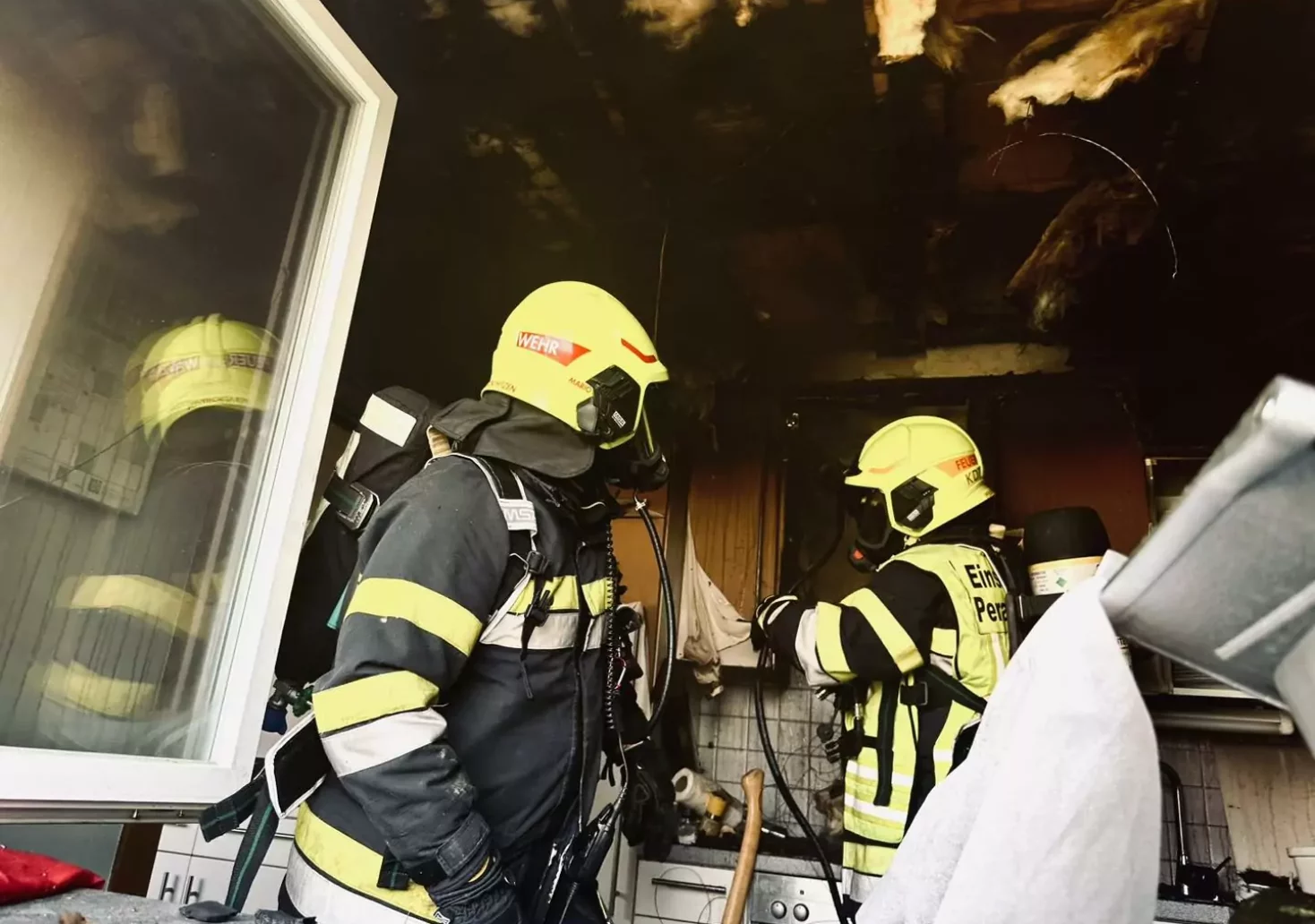 Bild auf 5min.at zeigt zwei Feuerwehrleute im Einsatz bei einem Küchenbrand.