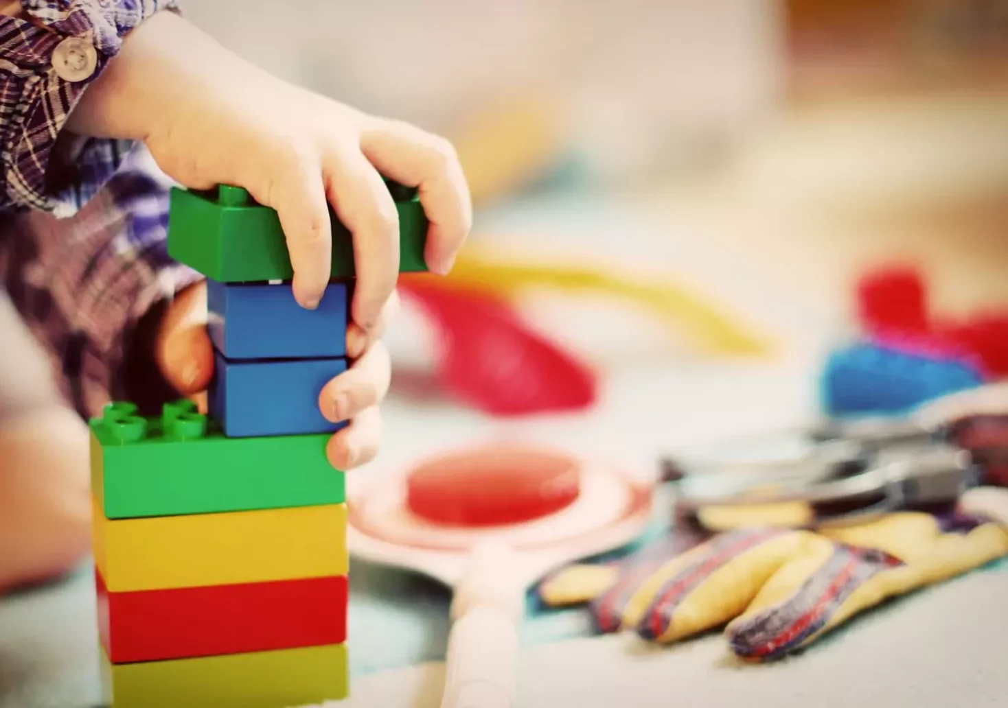 Das Bild auf 5min.at zeigt ein Kind beim Spielen mit Bausteinen.