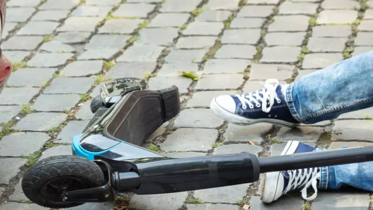 Ein Bild auf 5min.at zeigt einen Unfall mit einem Auto und einem E-Scooter Fahrer, der am Boden liegt.